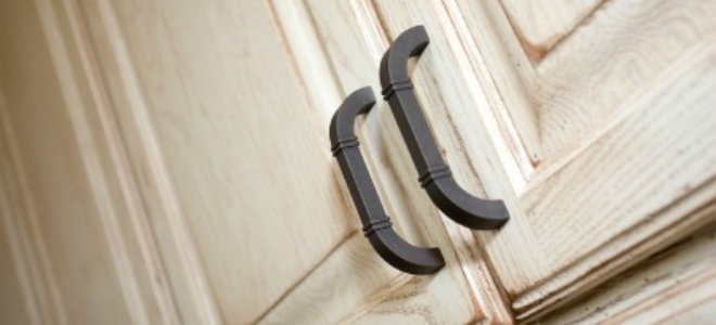 Dark handles contrast well against whitewashed kitchen cabinets doors.
