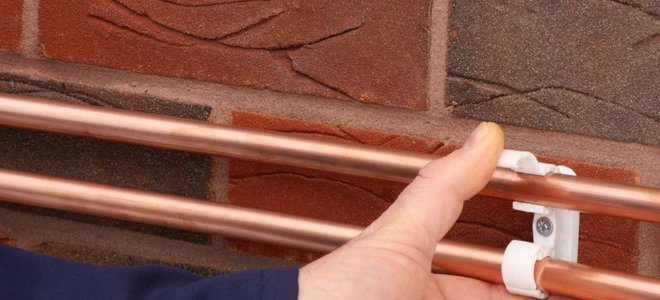 pushing copper pipes into supports