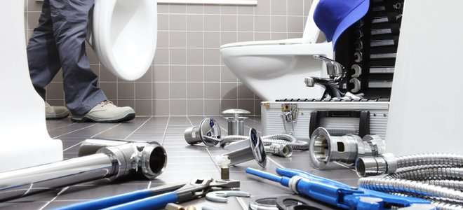 Plumbing tools near a toilet.