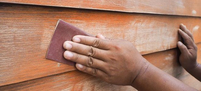 a person sanding siding