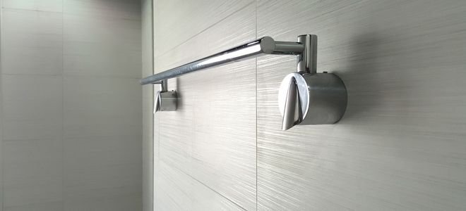 metal towel rack on gray tile wall