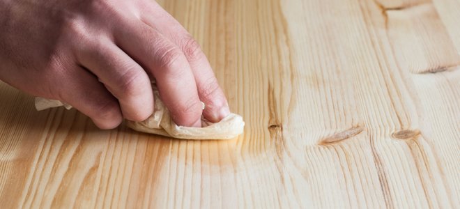 A man uses wood polish.