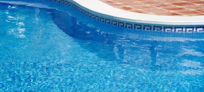 pool with curved edge and pavers around it