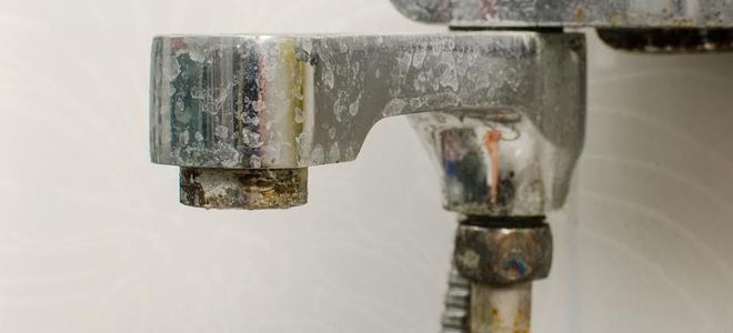 A faucet with mineral deposits on it.