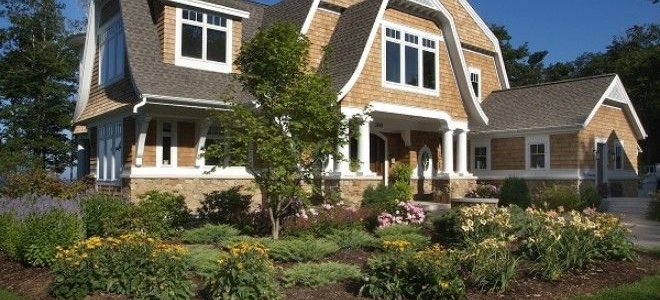 Farmhouse with gambrel roof and landscaping out front