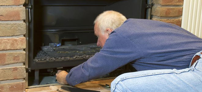Man installing a fireplace insert