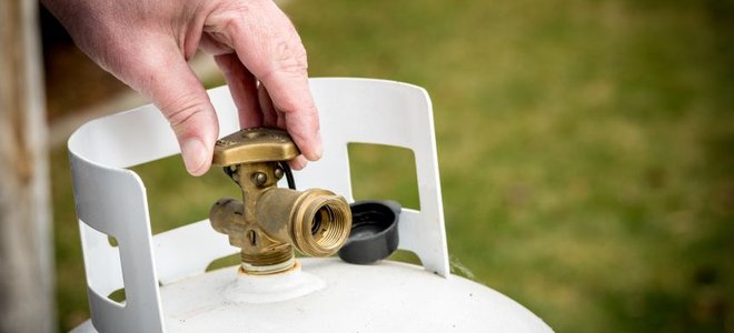 hand twisting a propane tank valve