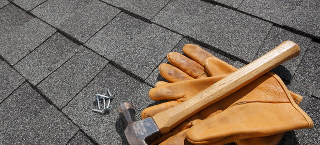 gloves and hammer on roof shingles