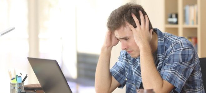 Man looking stressed staring at a computer