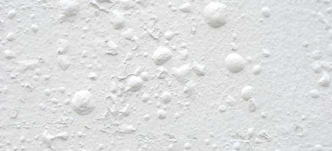 Blistering underneath a coat of white paint.