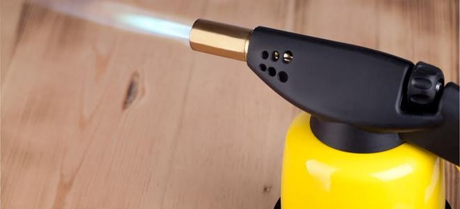 A yellow soldering torch with a flame.