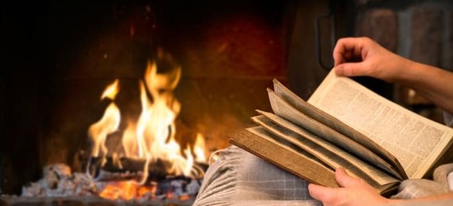 Reading a book by the fire. 
