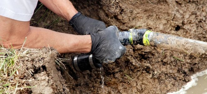 Person working on drainage pipes