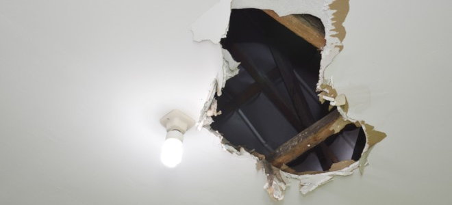 large hole in ceiling next to a light bulb