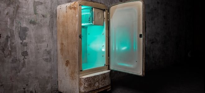 broken old refrigerator with light inside