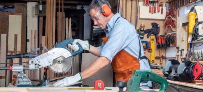 man using table saw with protective gear