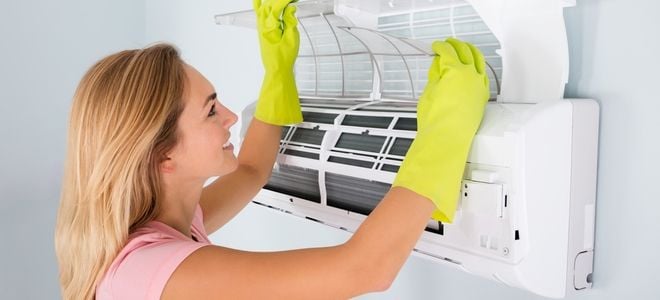 woman cleaning wall air conditioner filters
