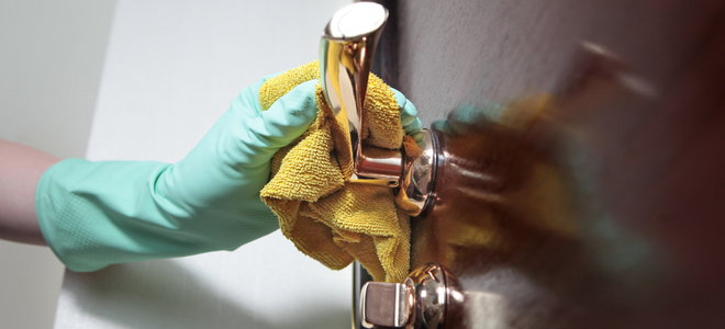 gloved hand polishing brass door handle