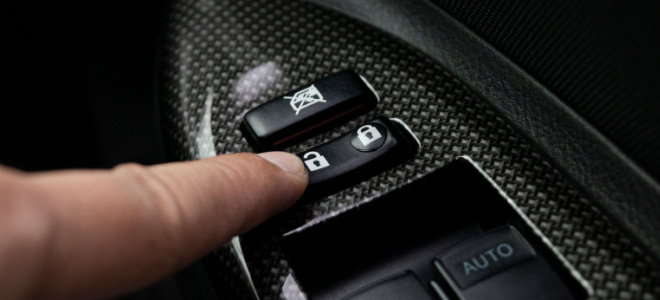 finger pressing car door lock button