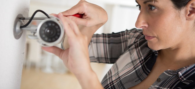 woman installing a security camera