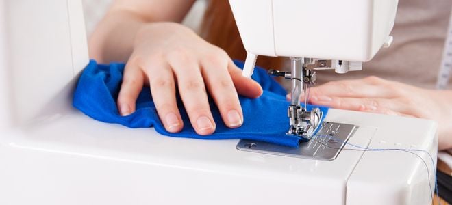 hands sewing fabric with machine