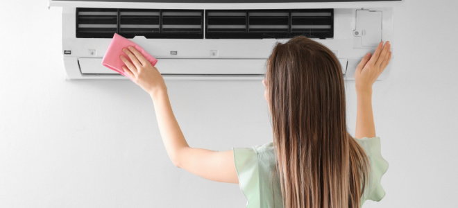 woman wiping air conditioner