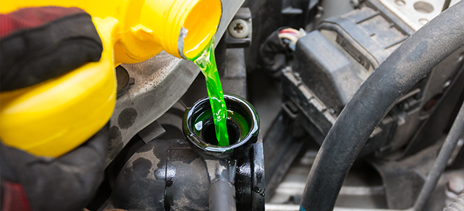 green fluid pouring into a car coolant system