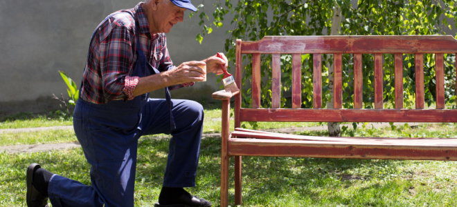 man painting garden bench