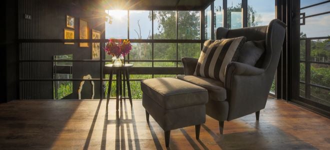 comfy arm chair in glass room with sunset