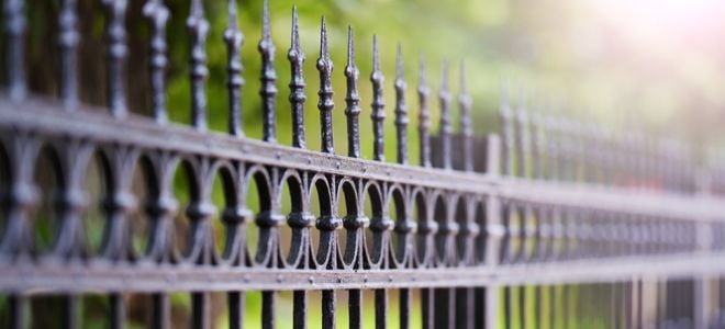 wrought iron fence with green background