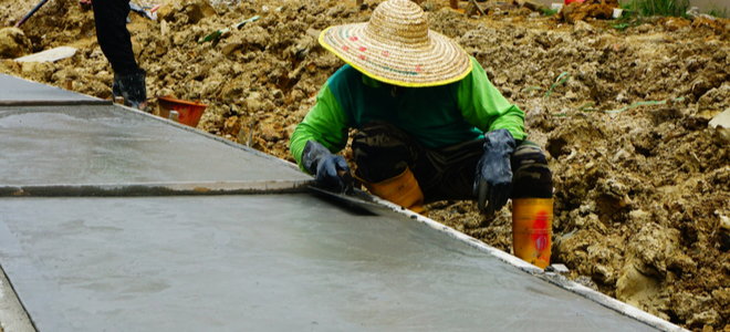 worker smoothing poured concrete slab