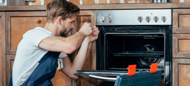 man repairing oven