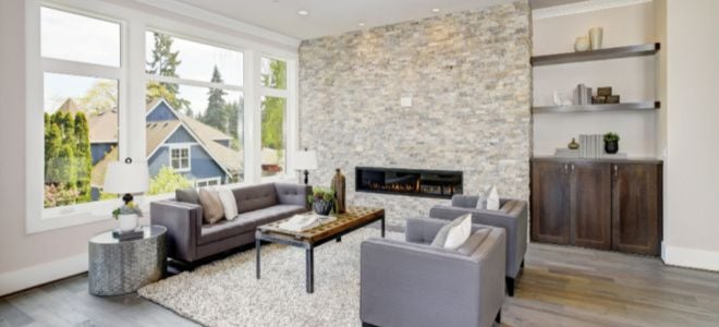 large windows in living room with stone wall and couches