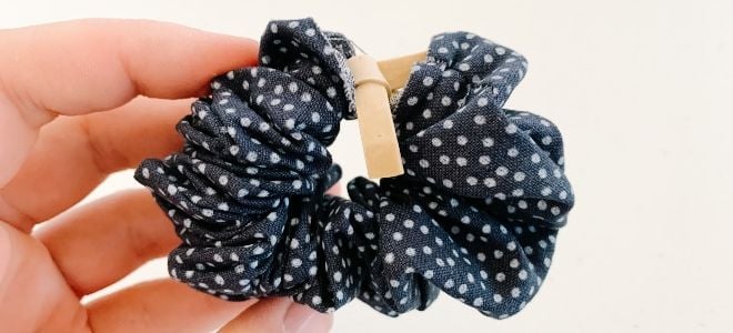 fingers holding polka dot scrunchie with rubber band