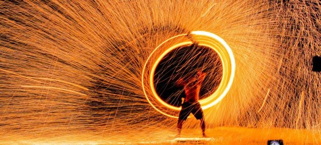 burning man scene with man spinning light and sparks