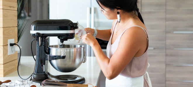 woman using KitchenAid machine mixer