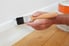 painting a white baseboard with a brush