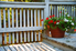 porch with a railing and potted flowers