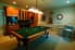 A room with a pool table and wine bar.