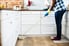 A woman cleans a kitchen.