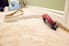 A worker cuts and installs bedroom carpet.