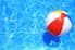A beautiful pool with a floating beach ball, waiting to be splashed into.