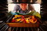 A tray of roasting vegetables being put in the oven. 