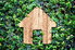 A wood outline of a house against an ivy backdrop. 