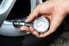 hand checking tire pressure with a gauge
