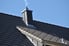 smoke puffing out of chimney on grey roof