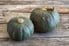 Two winter squash sitting on a wood surface.