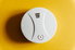 carbon monoxide detector on yellow wall
