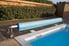 Rolled pool cover at the end of an inground pool