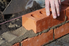 person laying bricks and mortar